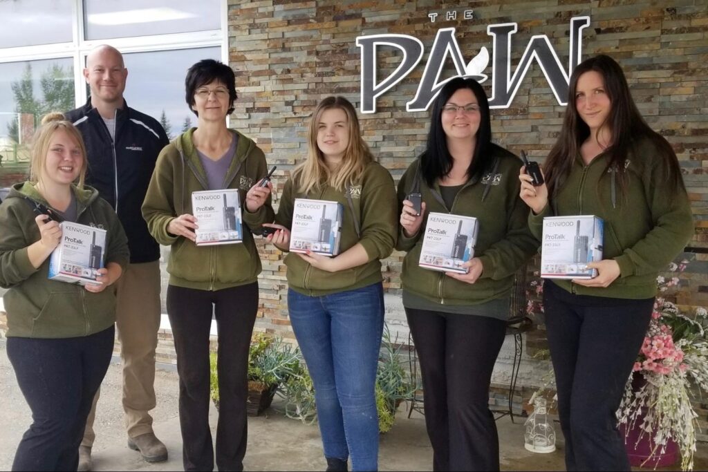 Group of employees holding up handheld walkie talkies